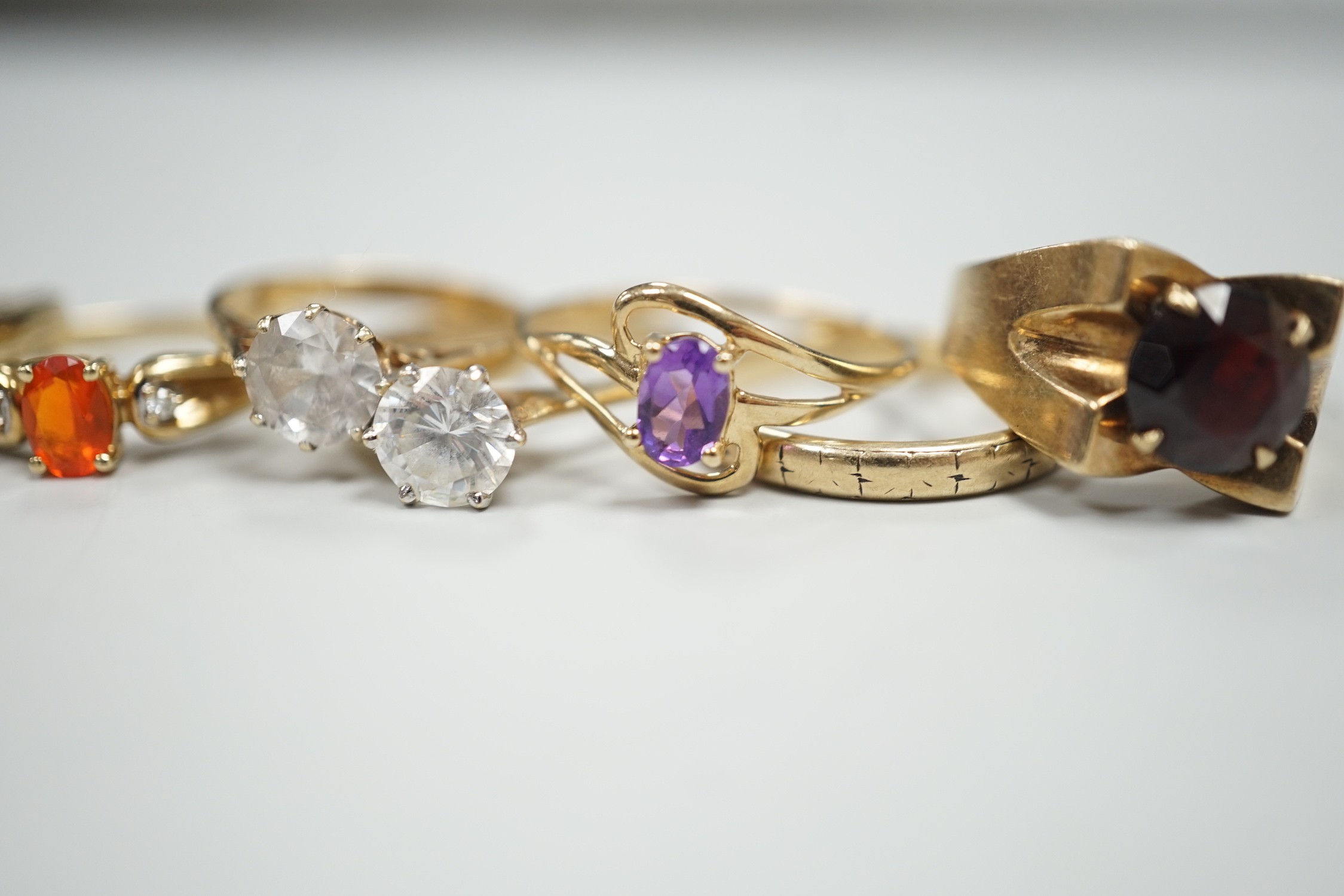 Six assorted modern 9ct gold and gem set rings, including amethyst and garnet single stone rings, together with a 9ct gold wedding band, gross weight 15.2 grams.